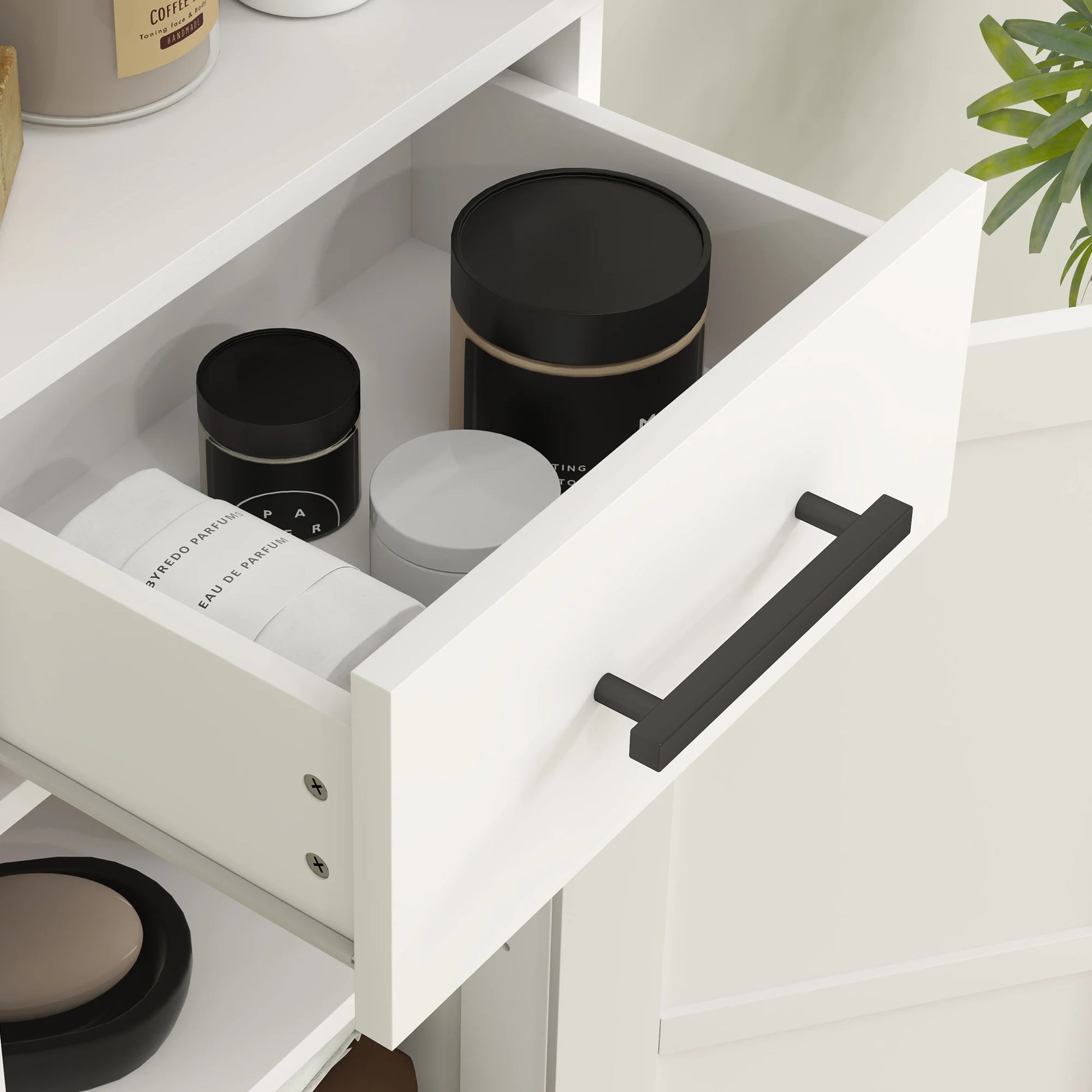 White tall bathroom storage cabinet with drawer, opened to reveal black round canisters inside.