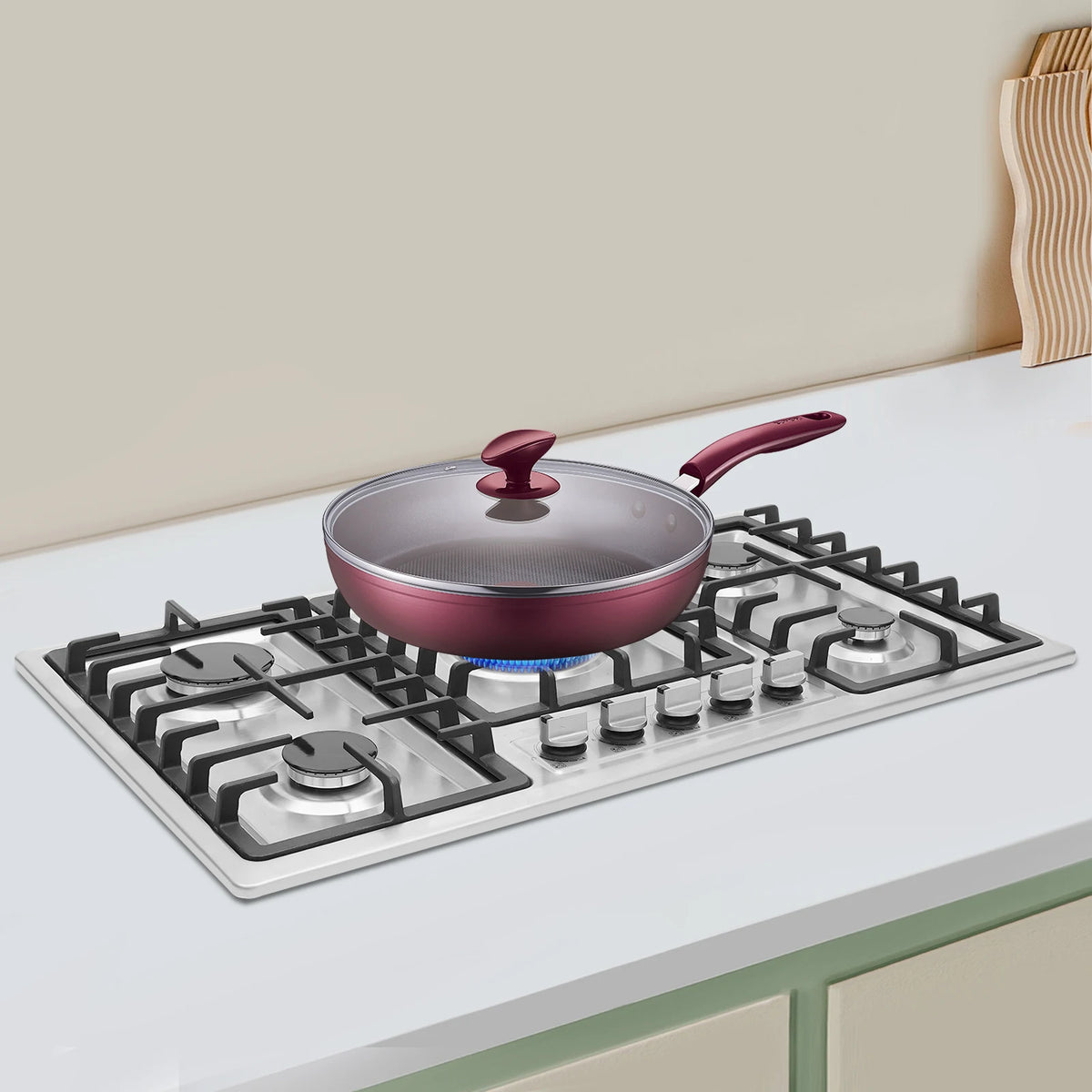 5-burner stainless steel built-in gas cooktop with purple pan and glass lid on the front burner
