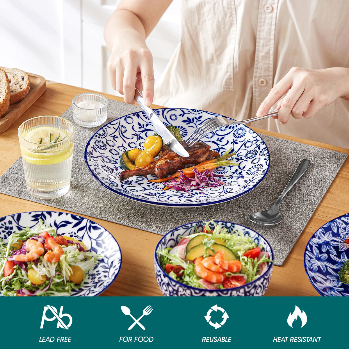 Blue and white porcelain plate set with floral pattern, shown with salads and lemon water on a wooden table