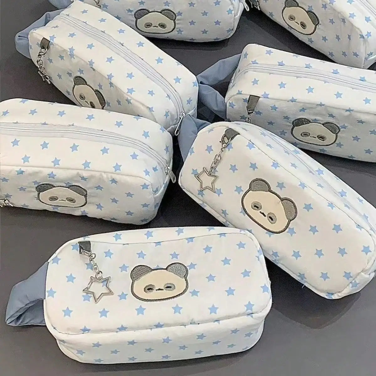 Six white panda-themed star-print pencil cases with blue stars and zip closures.