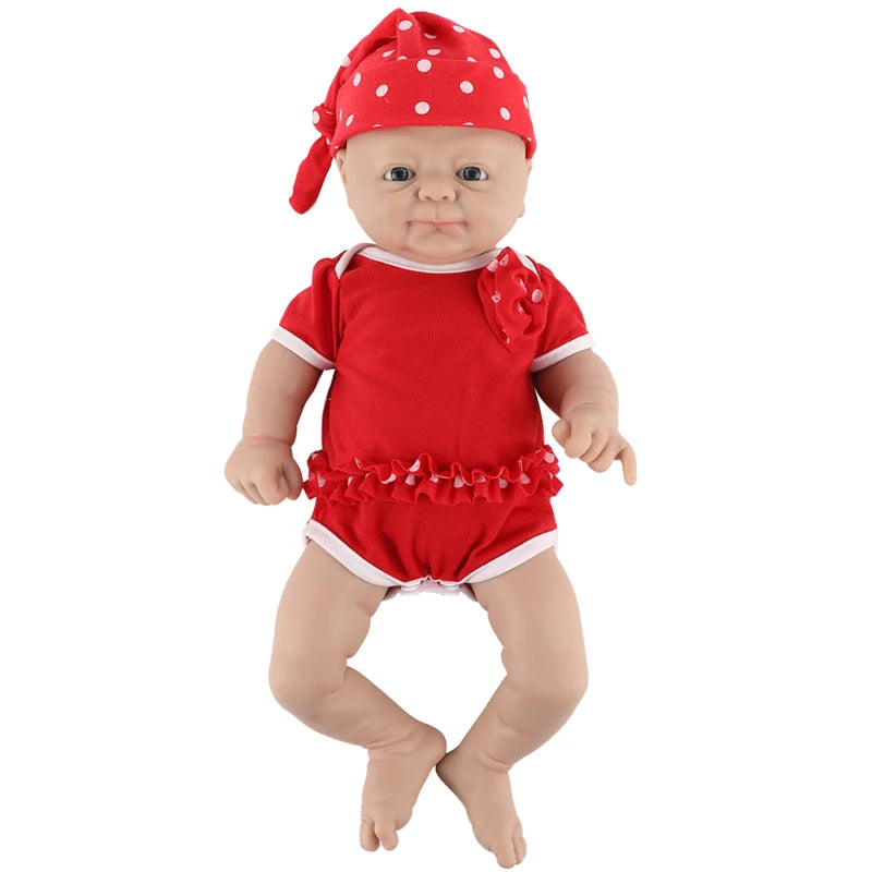 Silicone reborn baby doll in a red romper with white trim and ruffle, wearing a red polka-dot headscarf.